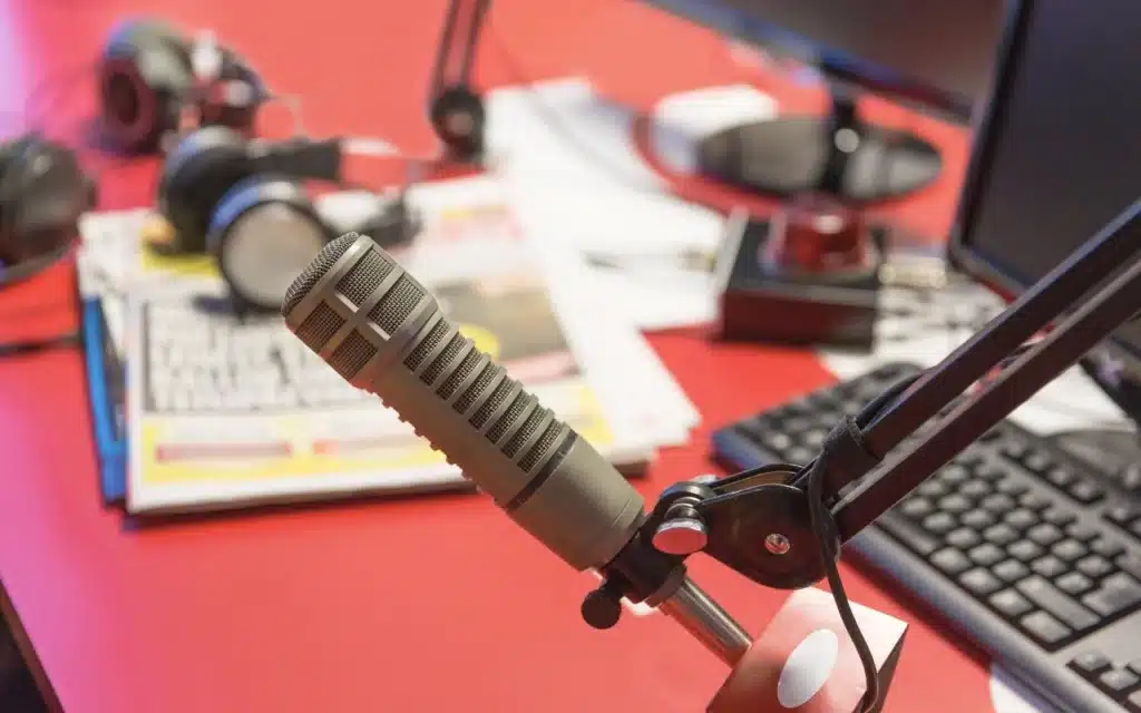 Microphone et équipement de podcast avec en arrière-plan une carte des Antilles Guyane, symbolisant l'introduction au podcasting dans la région.