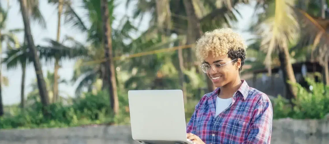 Entrepreneur aux Antilles Guyane travaillant sur un ordinateur dans un cadre tropical, symbolisant le marketing digital local.